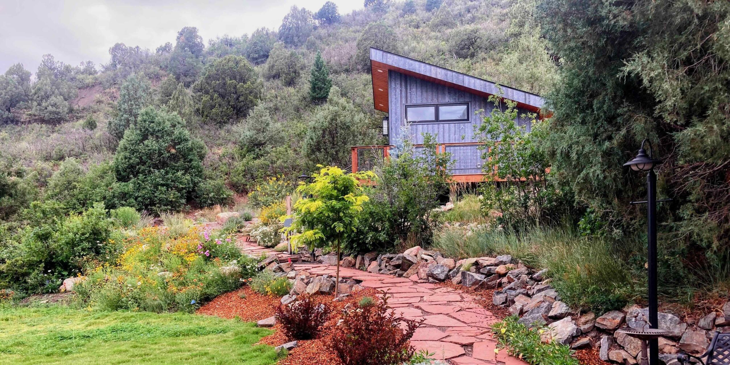A completed Columbine Landscapes project — mature plantings and stone hardscape in a Rocky Mountain setting