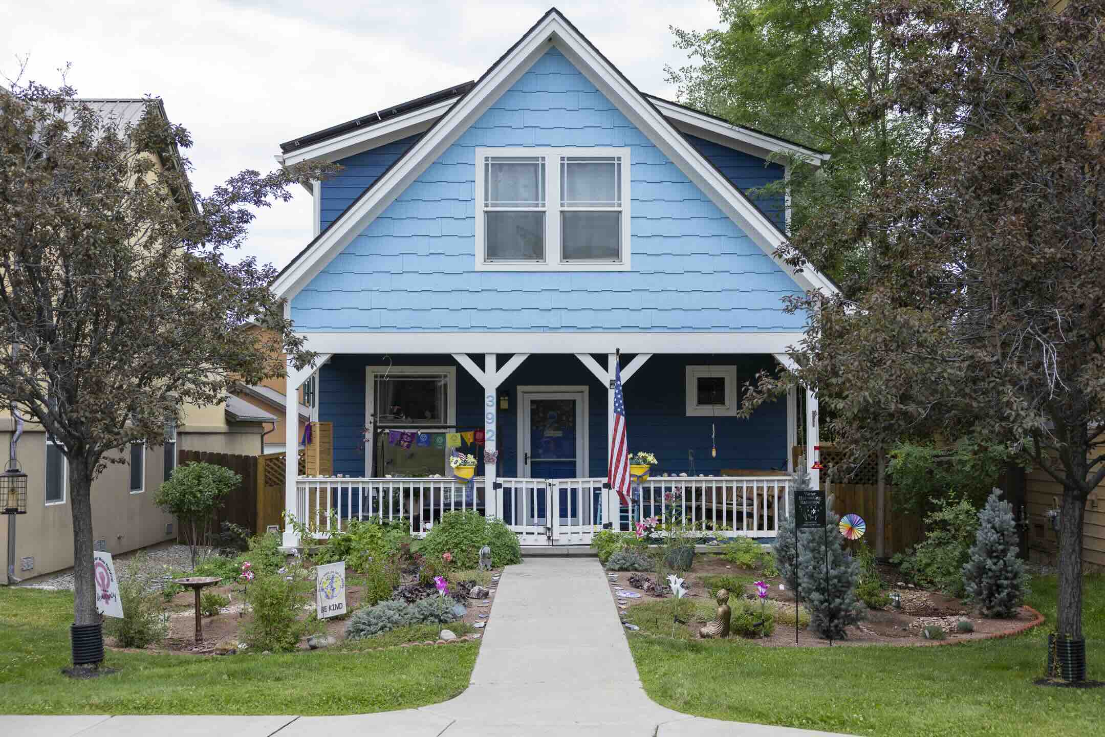 Front walkway garden with mixed perennials, spruce, and flowering plants at 3 Springs in Durango