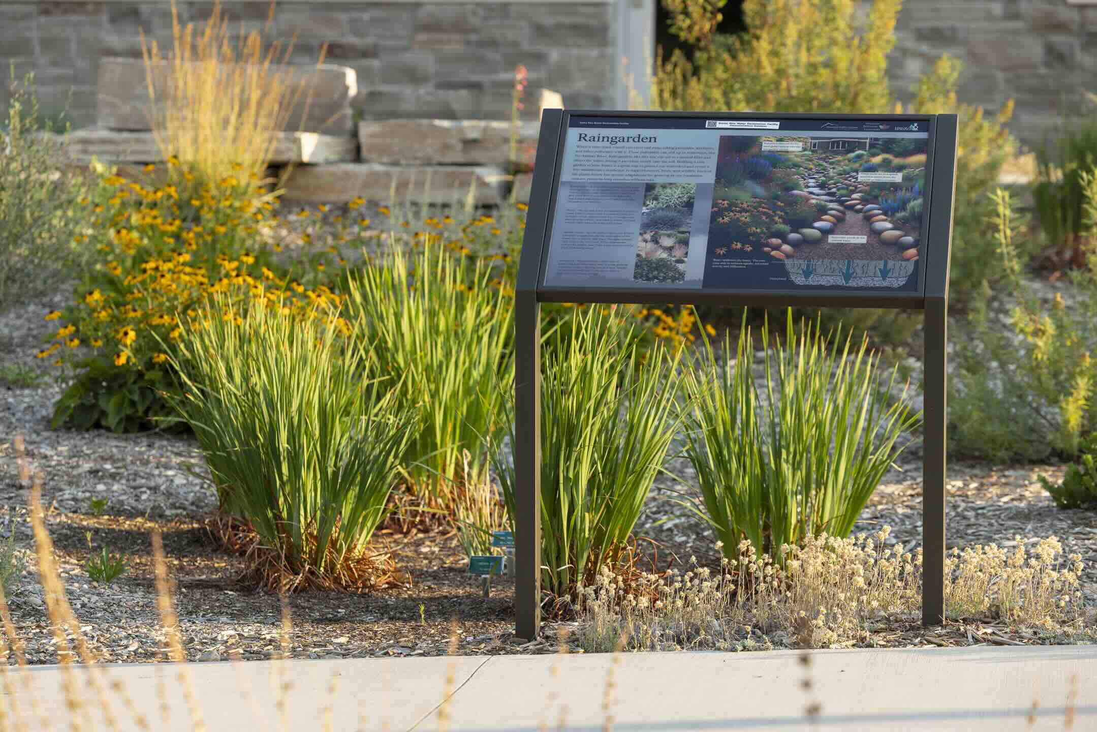 Educational rain garden interpretive sign among native plantings at Santa Rita Water Reclamation Facility